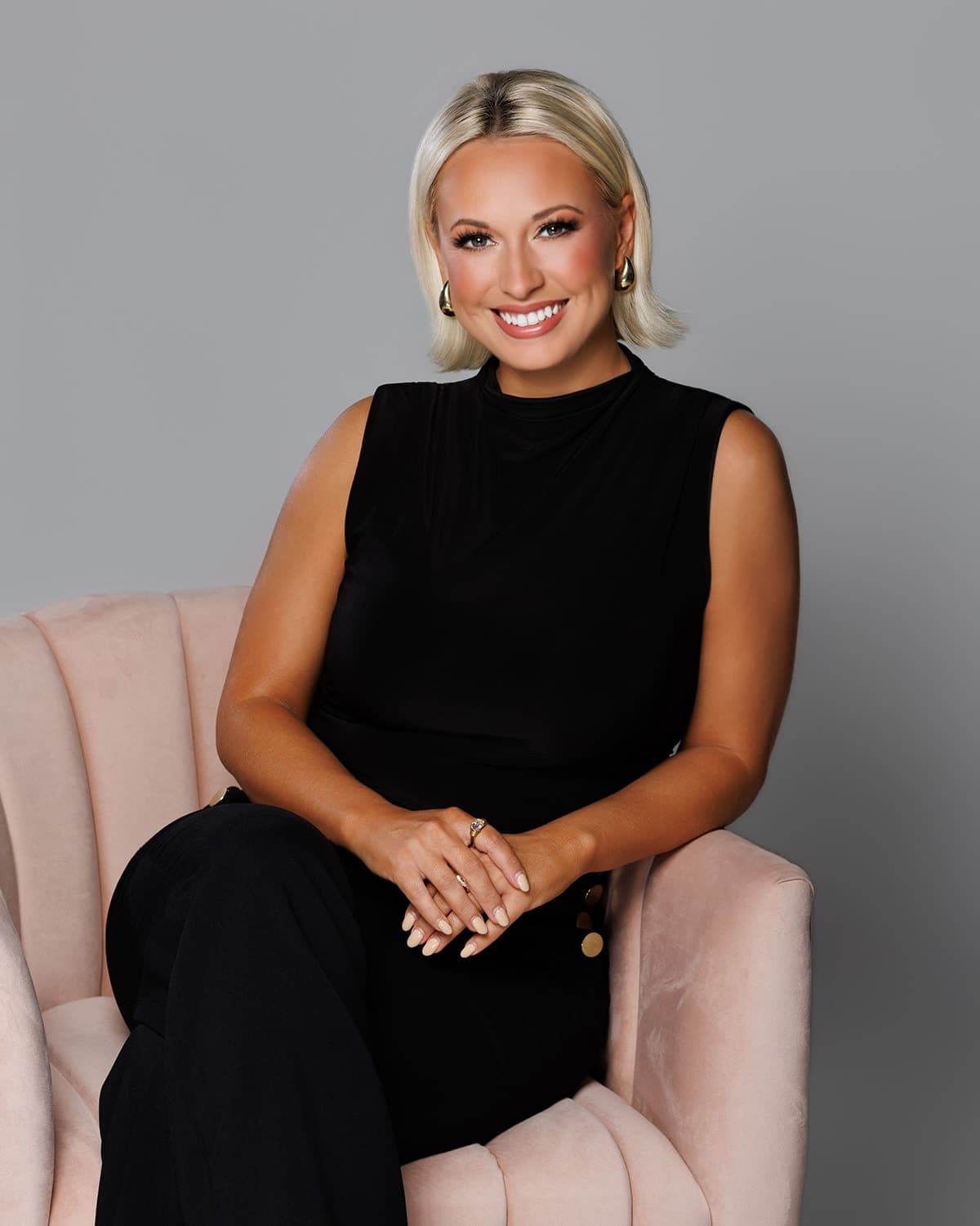 Lyndal Brumley smiling, seated in a blush velvet chair