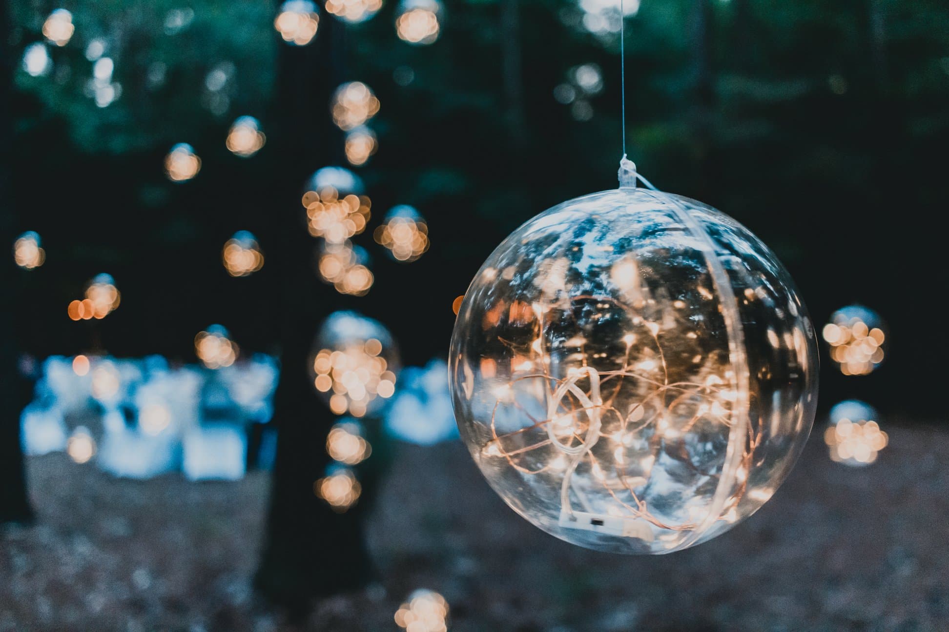 A glass orb hanging among warm evening lights